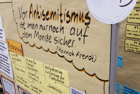 Pinnwand auf der ein Zitat von Hannah Arendt zu Antisemitismus steht und beschriftete Moderationskarten hängen.
