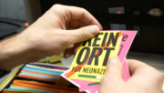 Sticker "Kein Ort für Neonazis" in der Hand einer Person