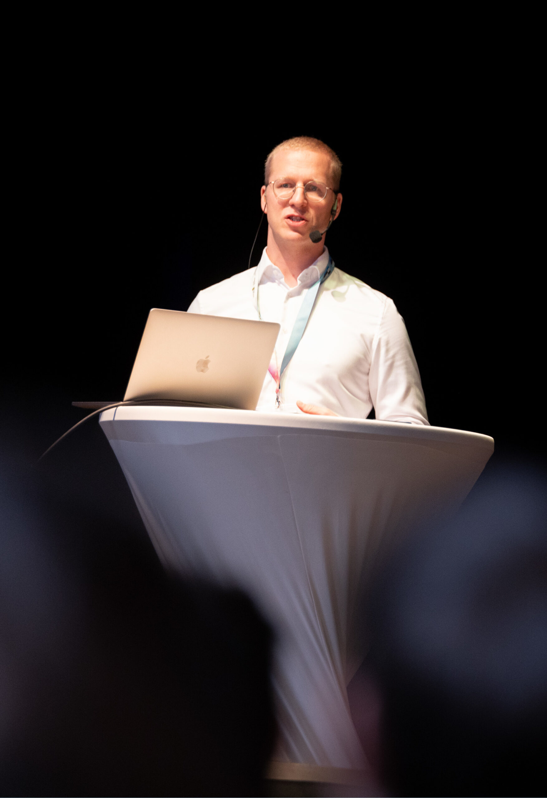 Dr. Johannes Kiess, Direktor des Else-Frenkel-Brunswik-Instituts, steht am Redepult mit Headset, vor ihm ein aufgeklappter Laptop