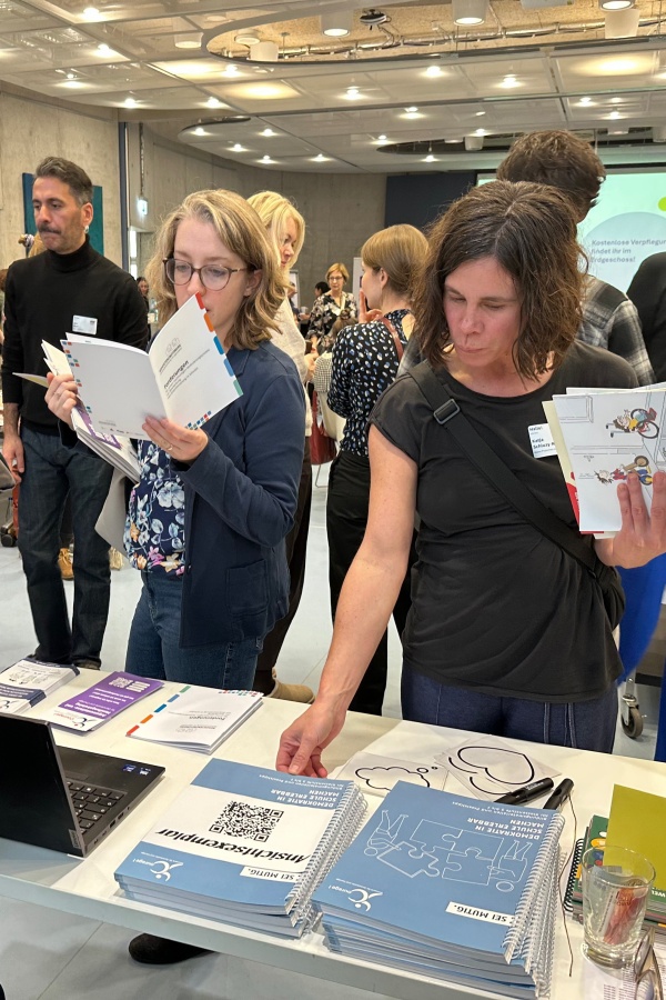 Zwei Personen stöbern in den Printprodukten des NDC