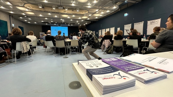 Blick auf Teilnehmende der Auftaktveranstaltung, im Vordergrund Flyer des NDC.