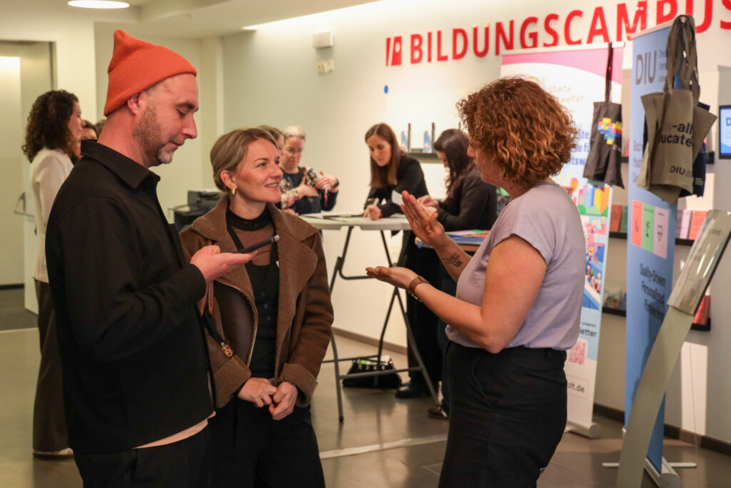 Teilnehmende, die in Kleingruppen miteinander diskutieren.