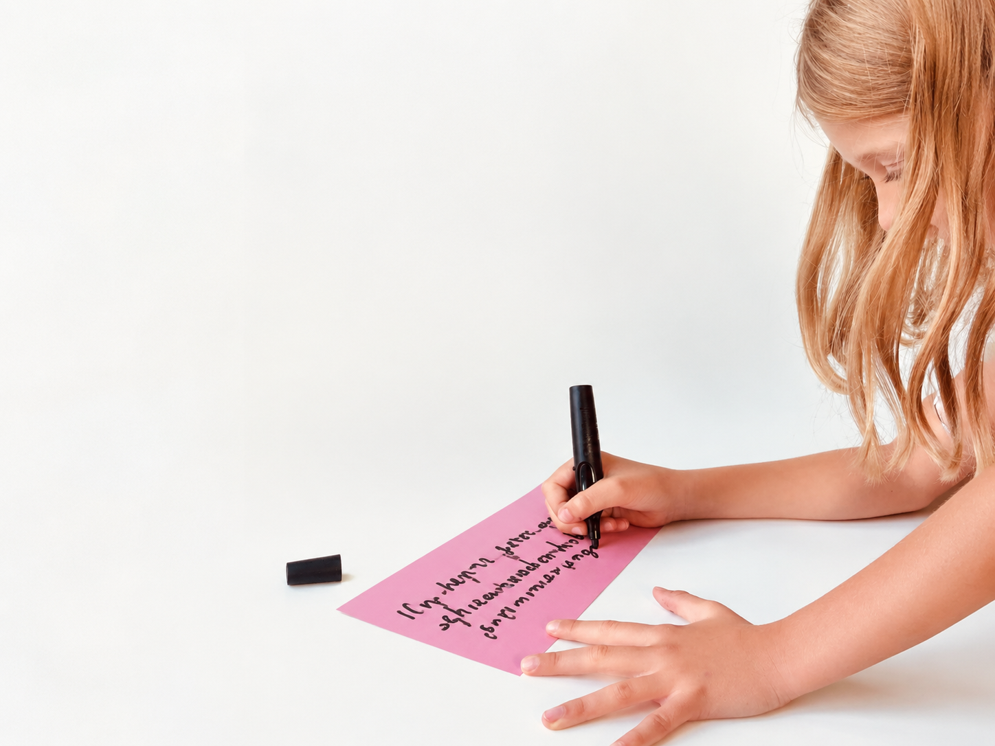 Covermotiv Handreichung "Methoden zur Demokratiebildung in Grundschulen": Ein Kind beschriftet eine Moderationskarte